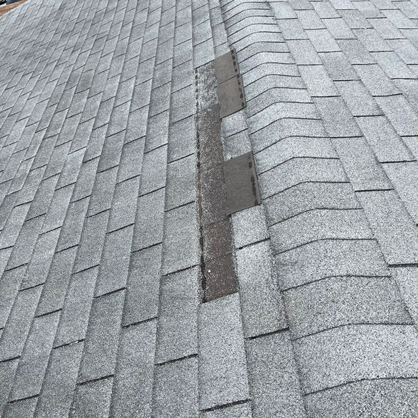 Section of roof showing shingles missing, highlighting a repair by Barry's Gutter and Home Repair